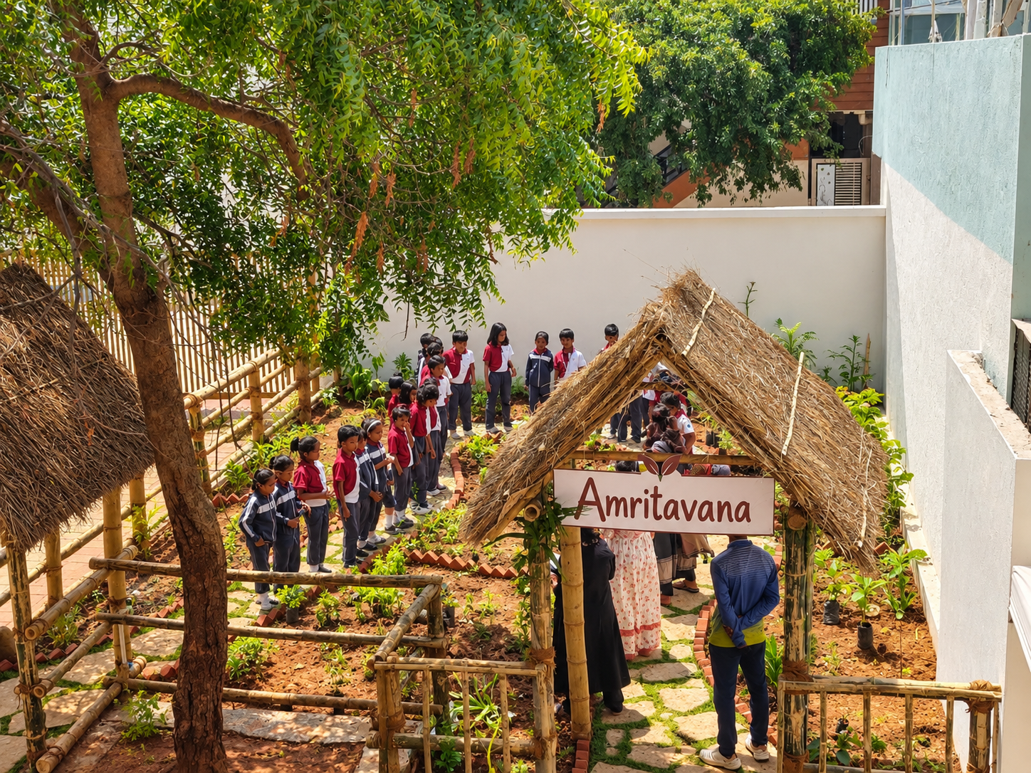 Students explore garden beds beneath a tree at Amritavana, IYRA International School’s living learning garden.